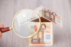 lente d'ingrandimento su una casa fatta di banconote da 50€
