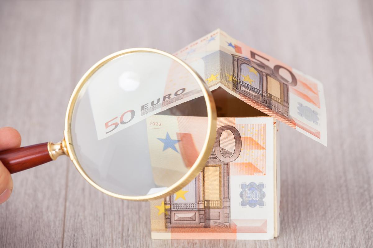 lente d'ingrandimento su una casa fatta di banconote da 50€