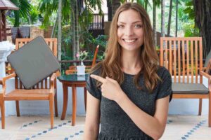 mobili da giardino in legno e donna che indica