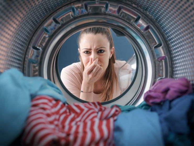 donna che si tappa il naso per la puzza nella lavatrice