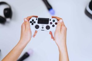 Persona che tiene in mano un pad PS4