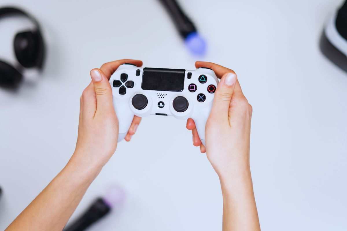 Persona che tiene in mano un pad PS4
